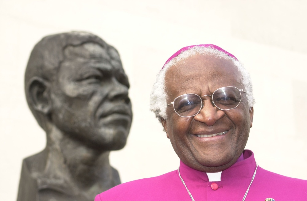 Desmond Tutu stands with a bust of former South African president Nelson Mandela in 2001 / Picture Credit: William Conran/PA Wire/PA Images