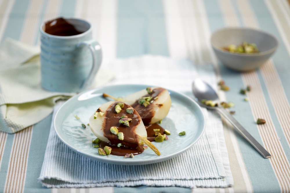 Poached pears with chocolate sauce and pistachios