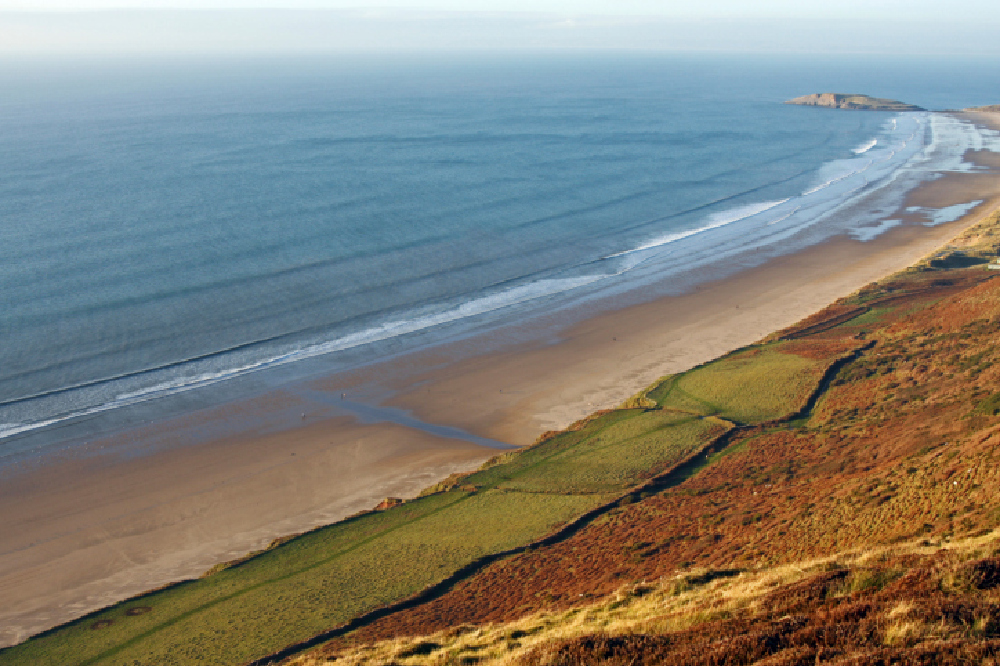 Swansea’s Rhossili Bay is officially the UK’s number one beach, and, taking third place in Europe and 10th in the world just goes to prove that you don’t have to travel thousands of miles for a great beach.  Rhossili Bay is the largest expanse of white sand on the Gower Peninsula and stretches for three miles. The beach’s vast stretch of sand and towering cliffs make it popular with surfers, paragliders and ramblers. The village of Rhossili is steeped in history and the wreck of the Helvetia, which ran aground on Rhossili Bay in November 1887 can still be seen on the beach today.