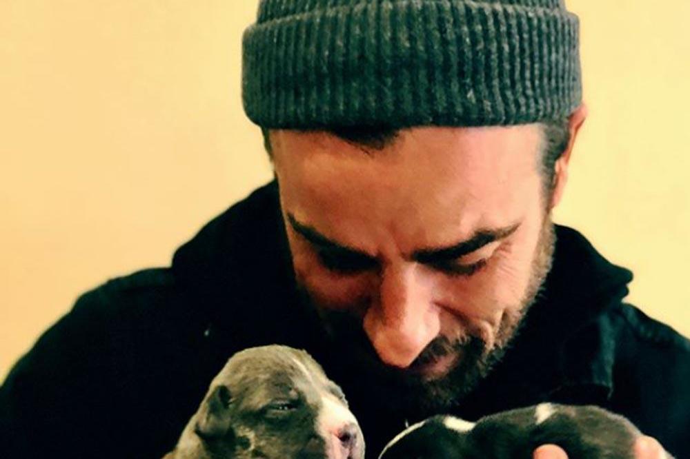 Justin Theroux cradles puppies (c) Instagram 