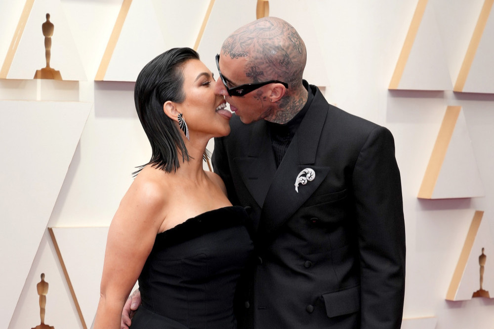 Kourtney Kardashian and Travis Barker have a reason for kissing with their tongues on the red carpet