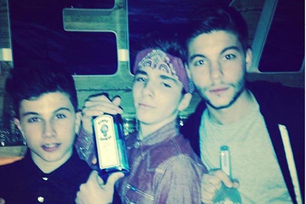 Rocco Ritchie (centre) holding a bottle of gin