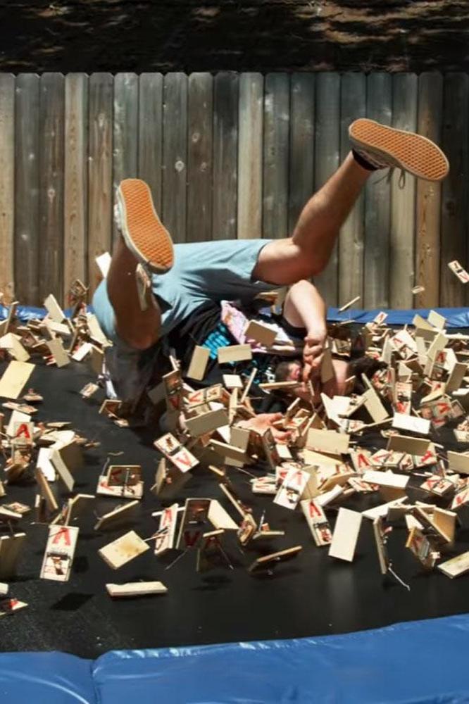 Man dives on a trampoline full of mouse traps