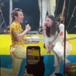 Harry Styles presenting the birthday cake on stage in Budapest