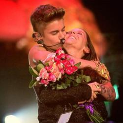 Justin Bieber kissing his mother Pattie Mallette on stage