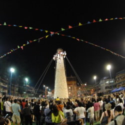 Brave competitors scramble up an enormous bamboo tower studded with imitation buns