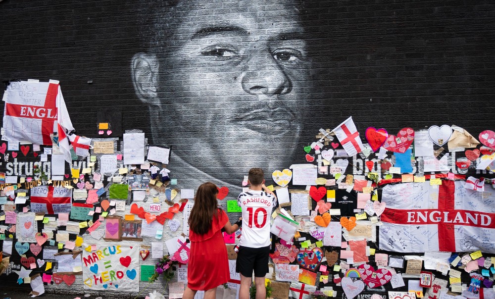Mackenzie Robertson and their mother Sally Coles-Robertson leave a message of support at the Marcus Rashford mural following England's Euro 2020 defeat / Picture Credit: Danny Lawson/PA Wire/PA Images