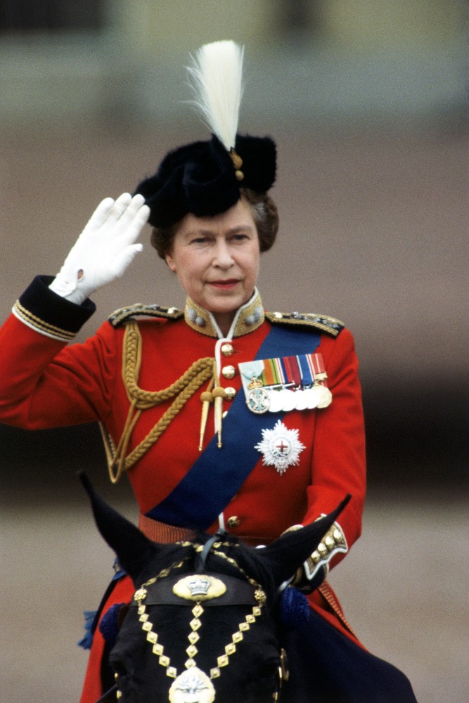 Queen Elizabeth II at the Trooping of the Colours, June 1984. On horseback, she here salutes, looking radiant in red and blue, complete with white gloves. / Picture Credit: Pictorial Press Ltd/Alamy Stock Photo