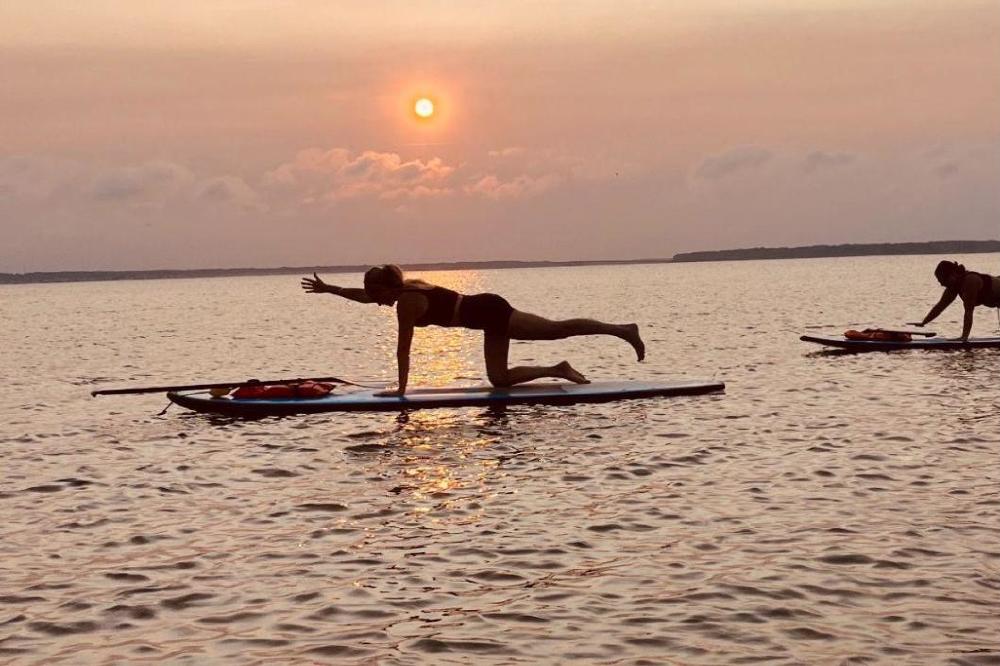 Tessa Arnold practicing paddleboard yoga as part of a Ayuverdic lifestyle