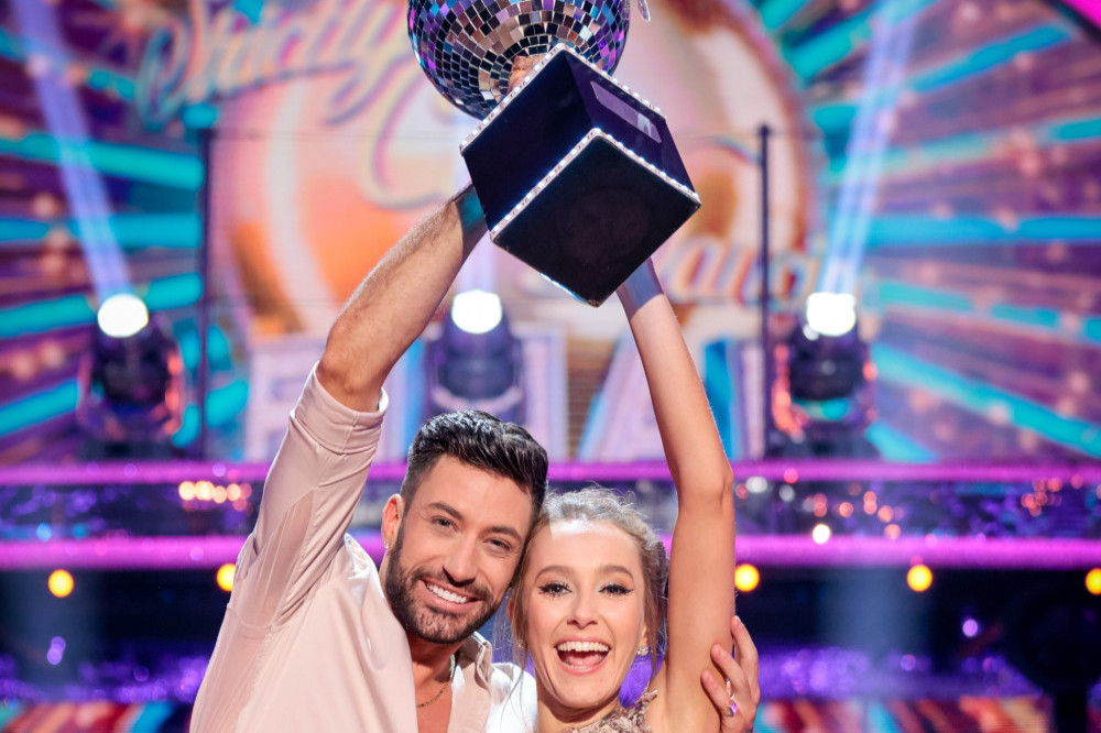 Giovanni Pernice and Rose Ayling-Ellis lifting the Strictly Come Dancing glitterball trophy