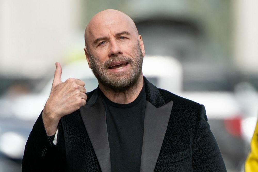 Bald John Travolta encouraged by Pitbull
