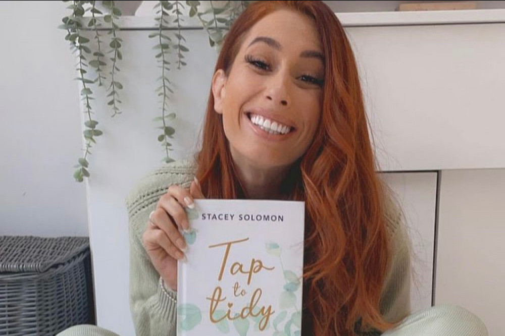 Stacey Solomon with her Tap To Tidy book