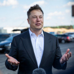 Elon Musk is standing by a blue tick fee