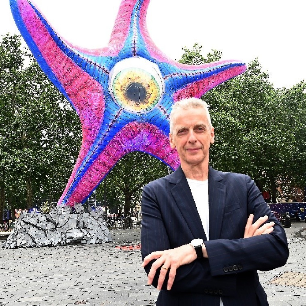 Peter Capaldi with the Starro statue in London / Picture Credit: Warner Bros. Pictures